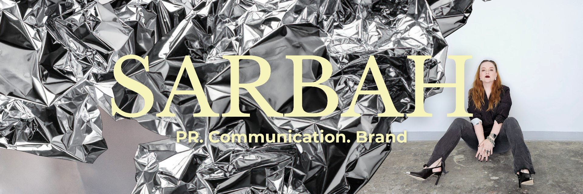 Ester Kannelmäe, founder of SARBAH, seated in front of a silver foil installation.